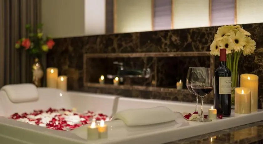 Private whirlpool bathtub prepared with flowers and wine